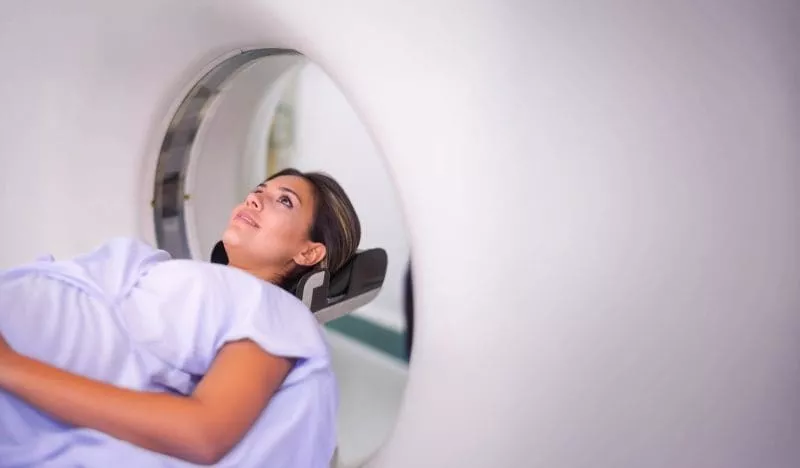 Patient lying on an MRI scanner bed, looking upward inside the machine.